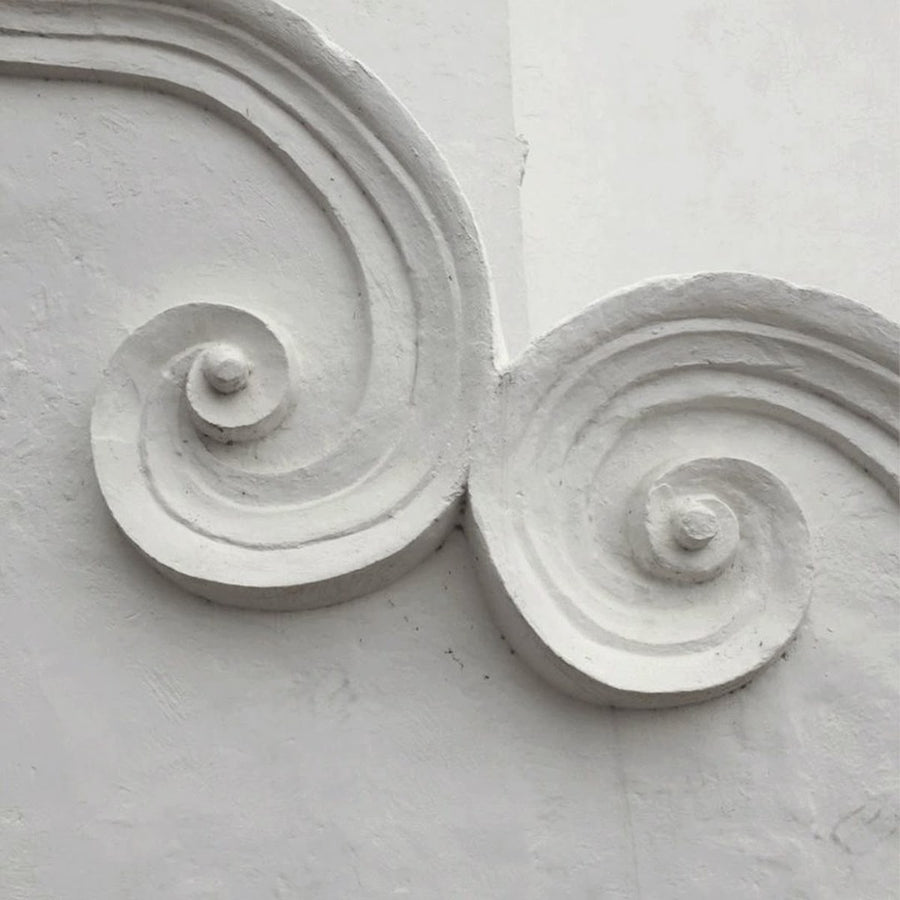 plaster scrollwork on a white wall
