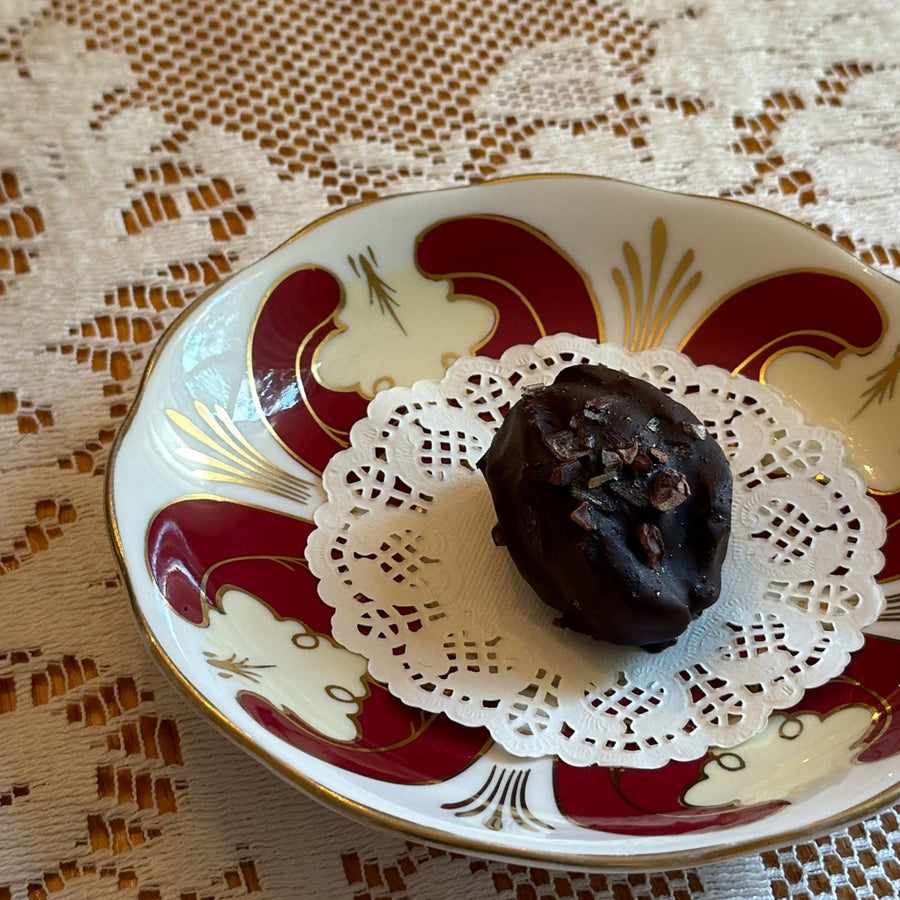 a cacao espresso date truffle on a vintage saucer