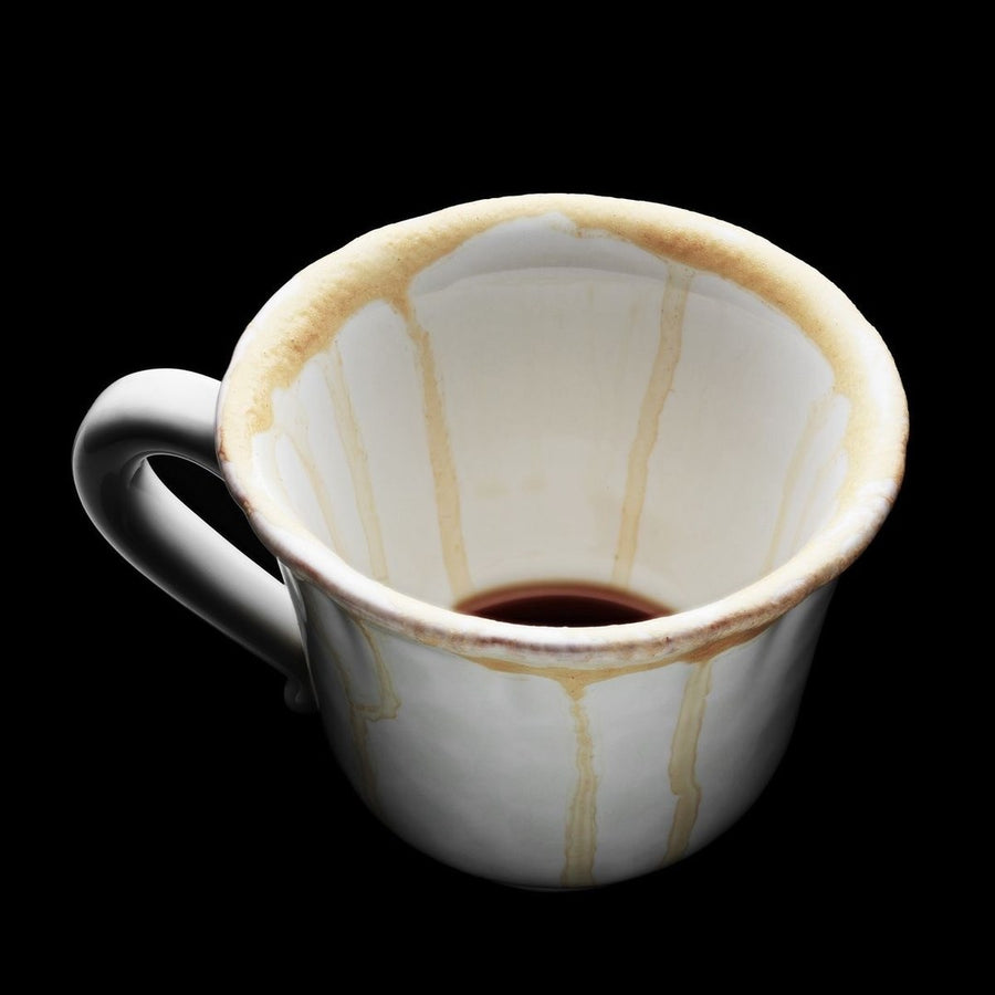 an empty coffee cup with drips down the side